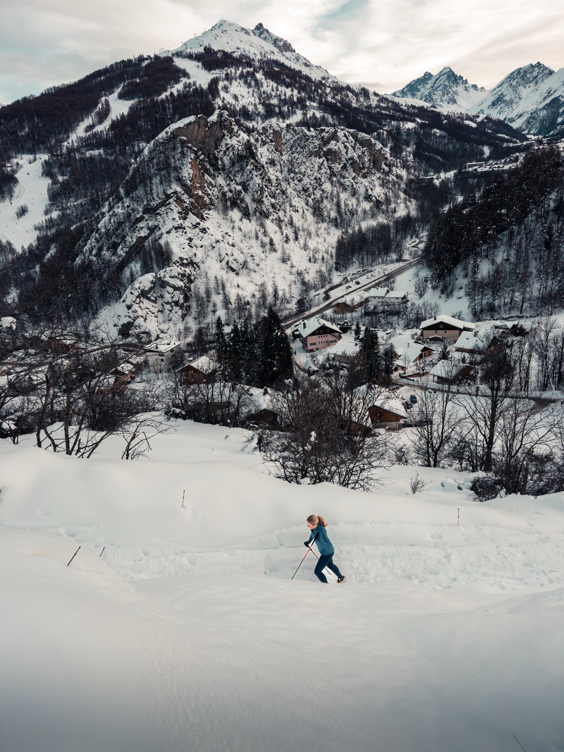 Trail running in snowy mountain landscape with alpine village
